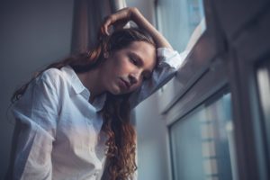 teen looking out window during co-occurring disorder treatment